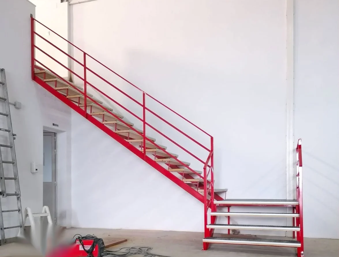 Escalera metálica roja fabricada a medida para nave industrial en Murcia
